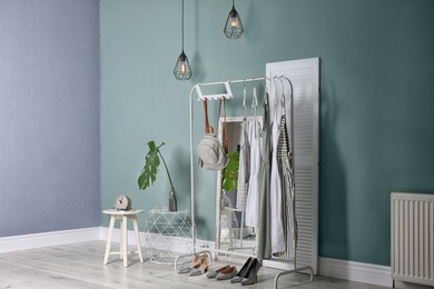 Photo of Stylish dressing room interior with clothes on rack