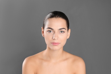 Photo of Portrait of beautiful young woman on grey background. Lips contouring, skin care and cosmetic surgery concept