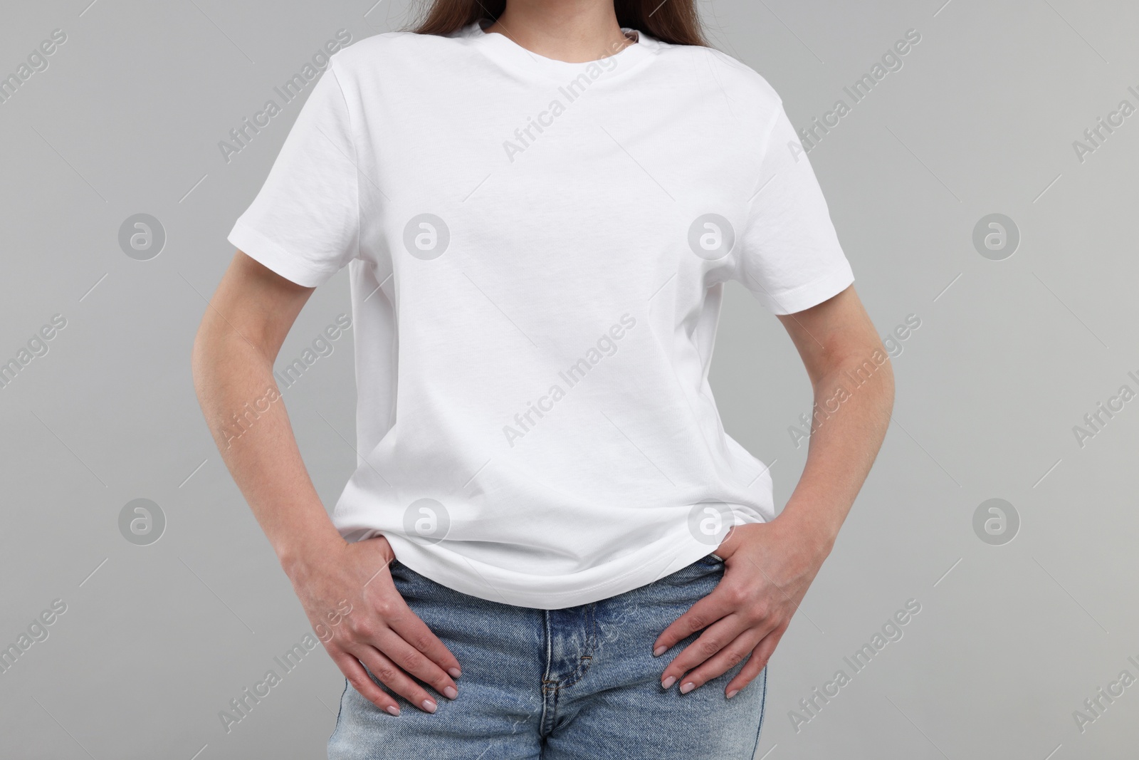 Photo of Woman in white t-shirt on grey background, closeup