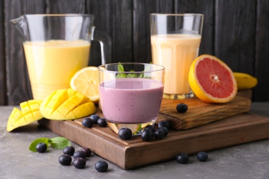 Photo of Glassware with healthy detox smoothies and ingredients on table