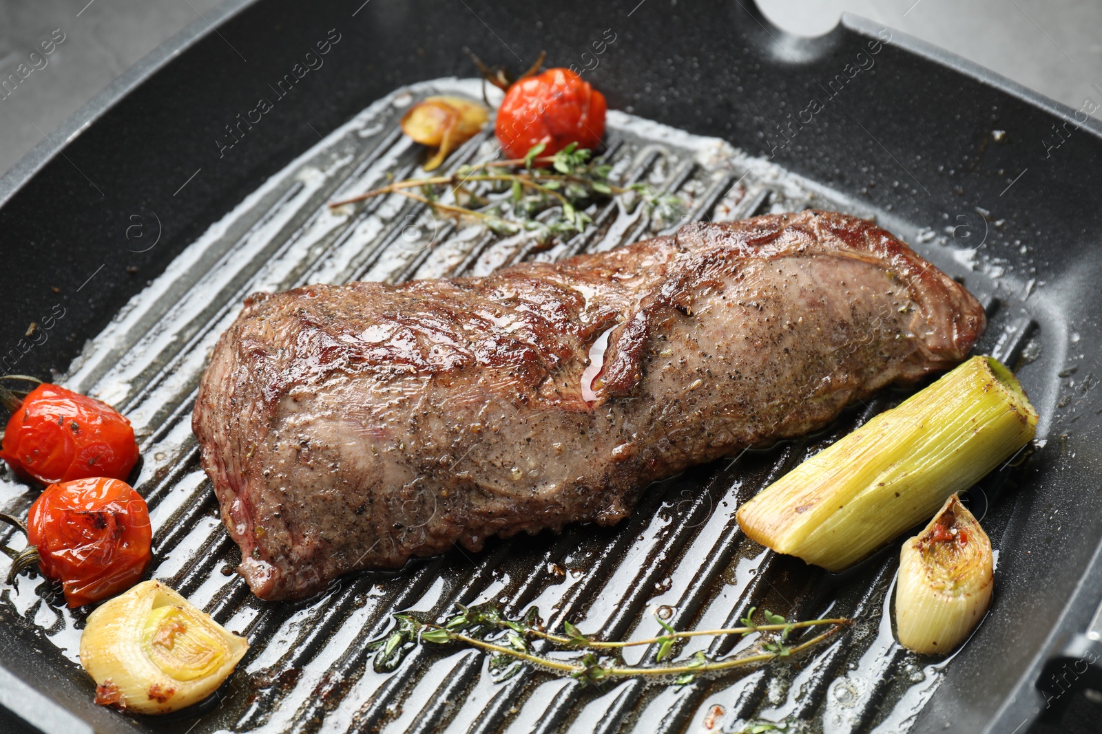 Photo of Delicious grilled beef meat and vegetables in pan, closeup