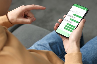 Man texting via mobile phone indoors, closeup. Device screen with messages