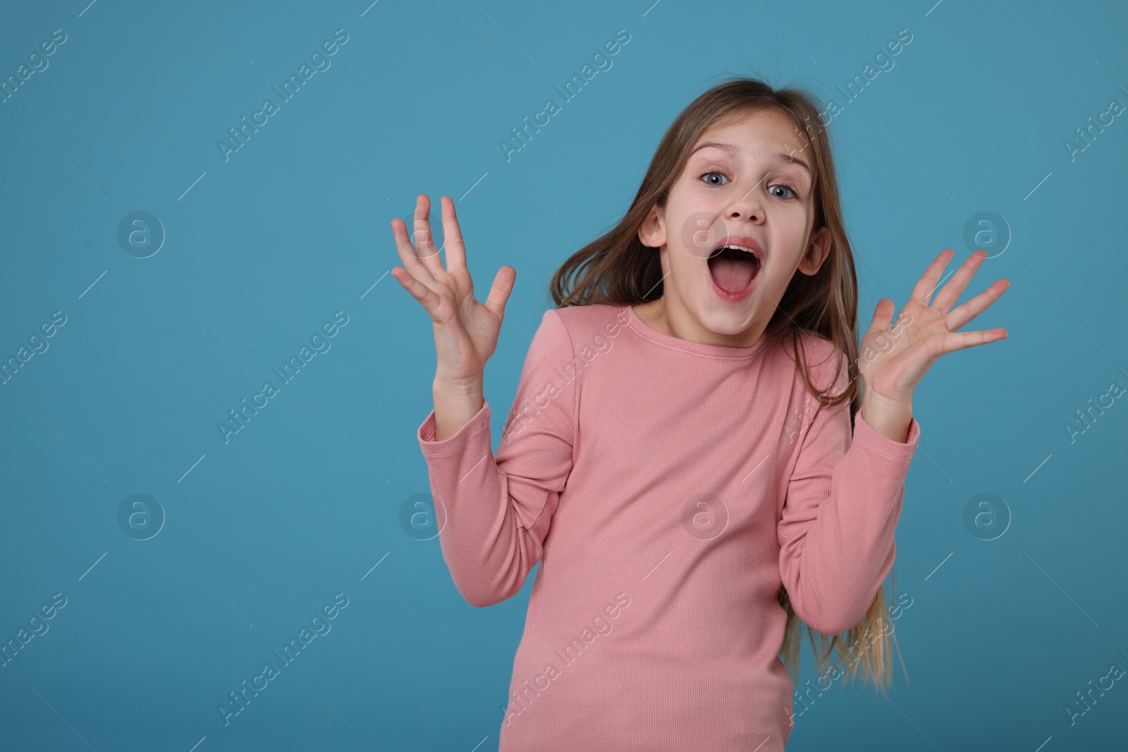 Photo of Portrait of surprised girl on light blue background