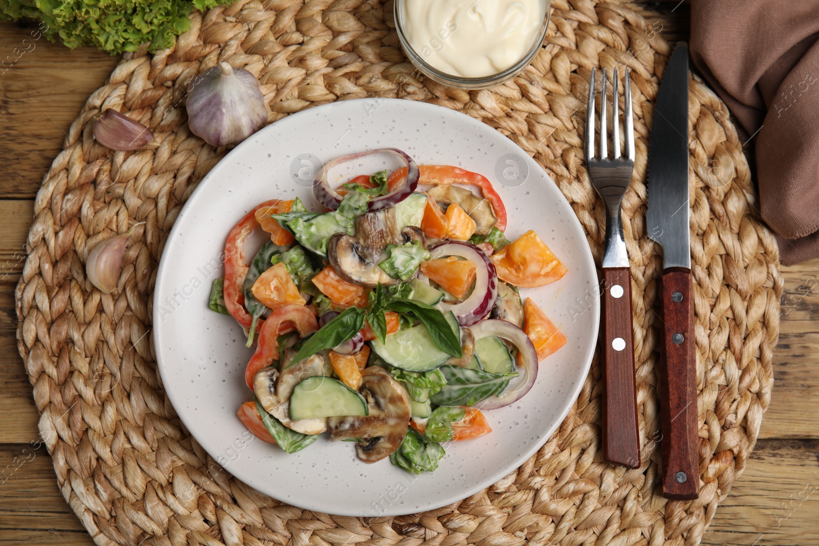 Photo of Delicious salad with mayonnaise served on wooden table, flat lay