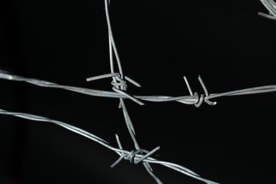 Metal barbed wire on black background, closeup