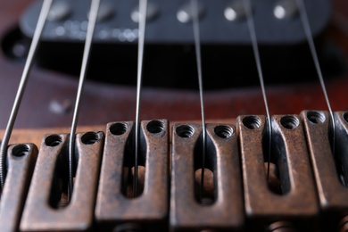 Photo of Closeup view of electric guitar, focus on bridge with strings