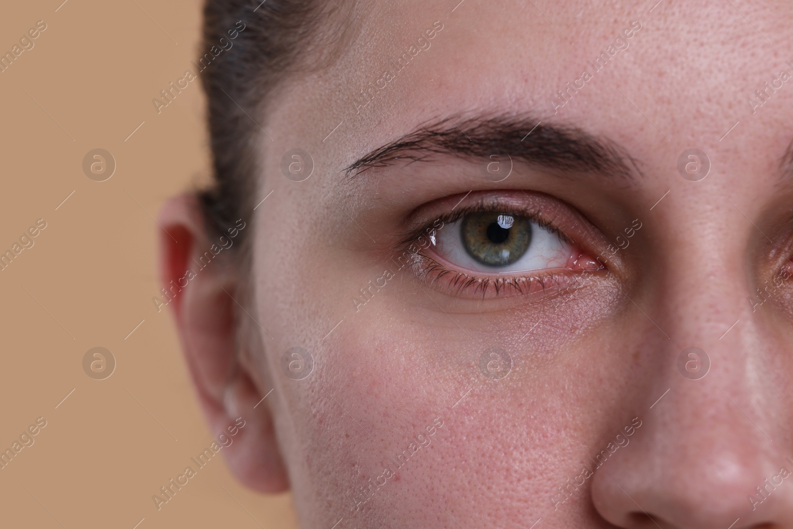 Photo of Closeup view of woman with beautiful hazel eyes on beige background