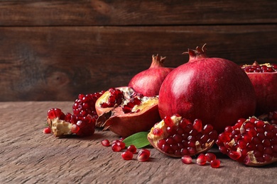 Photo of Composition with ripe pomegranates and leaves on table. Space for text