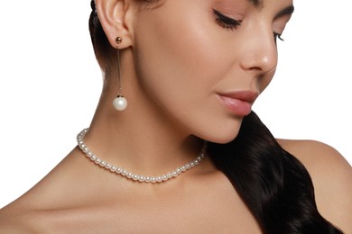 Photo of Young woman wearing elegant pearl jewelry on white background, closeup
