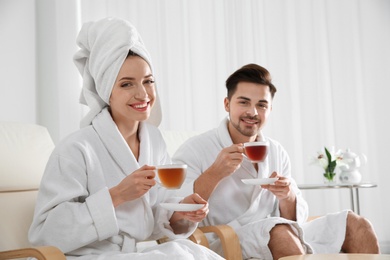 Photo of Romantic young couple with tea in spa salon