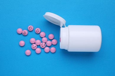 Photo of Pink antidepressants and medical bottle on light blue background, flat lay