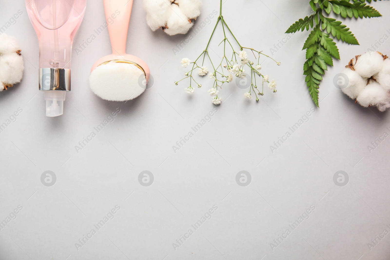 Photo of Flat lay composition with face cleansing brush on light grey background. Cosmetic accessory