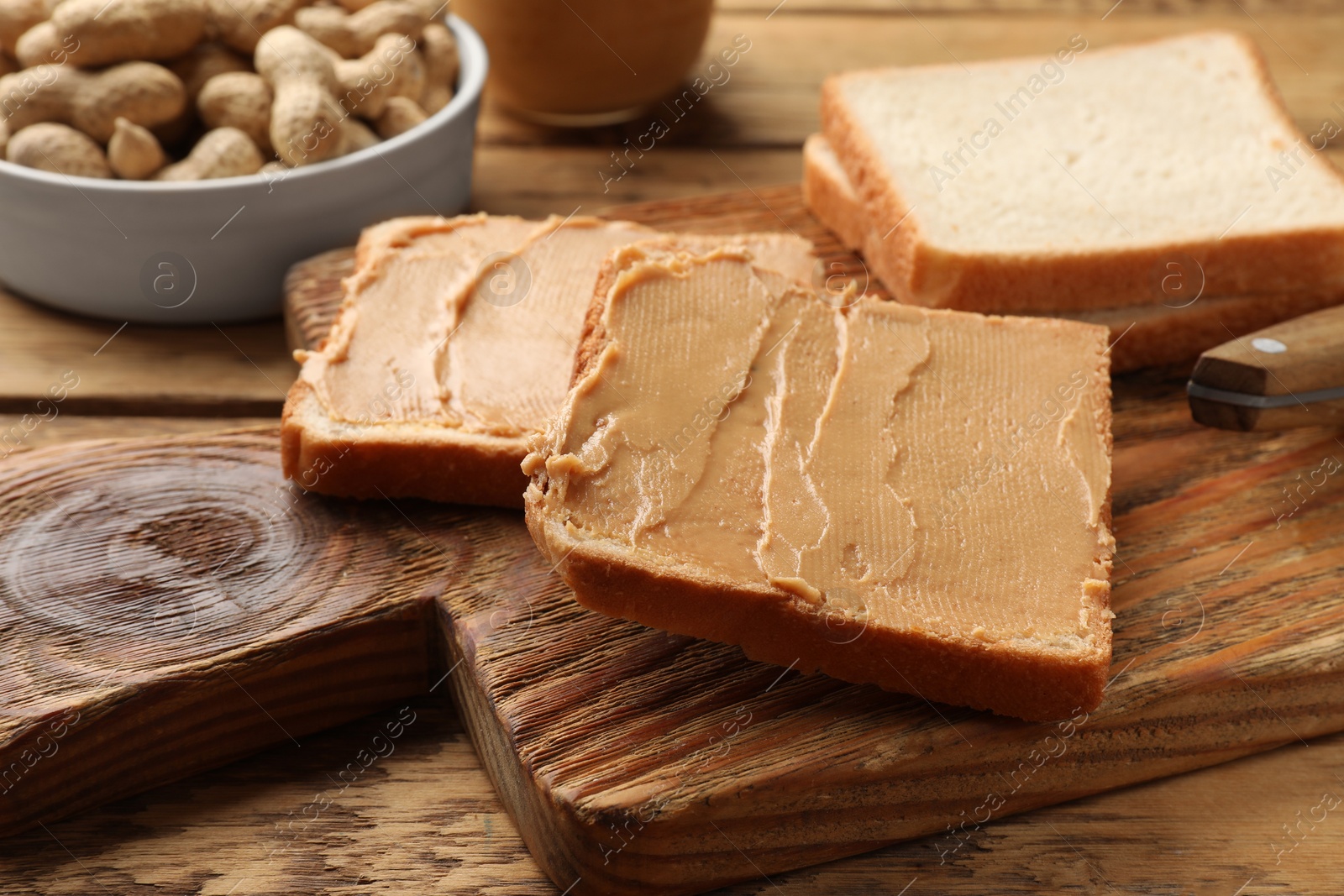 Photo of Tasty peanut butter sandwiches on wooden table, closeup view