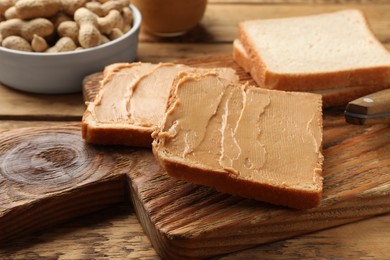 Photo of Tasty peanut butter sandwiches on wooden table, closeup view