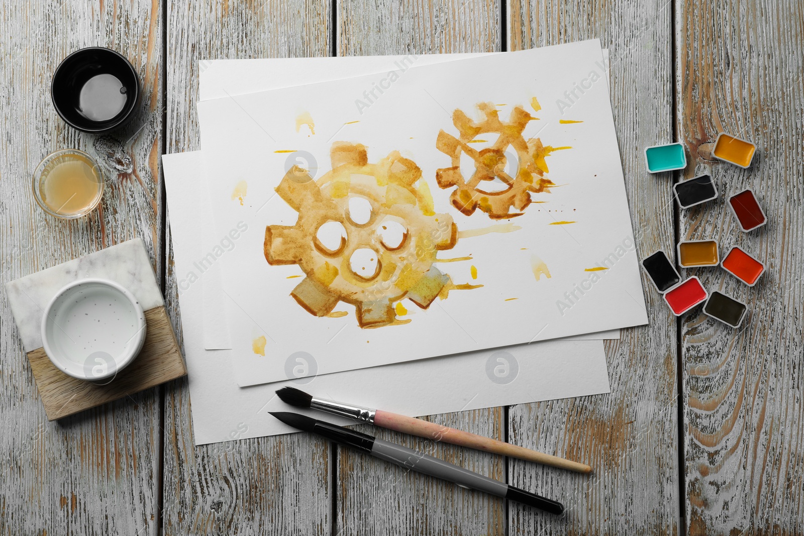 Photo of Flat lay composition with watercolor painting of gears and paints on light grey wooden table