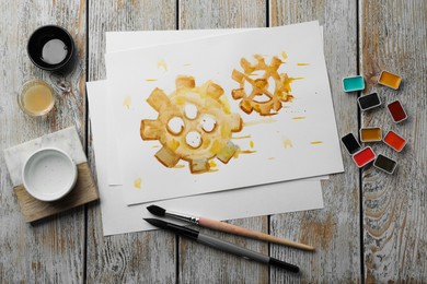 Flat lay composition with watercolor painting of gears and paints on light grey wooden table
