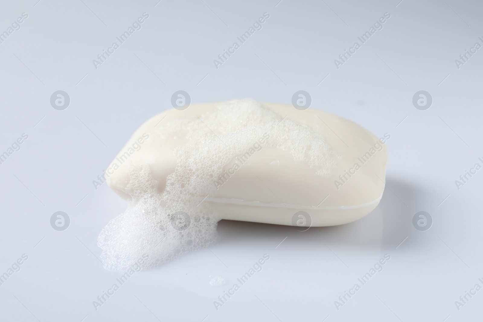 Photo of Soap with fluffy foam on white background