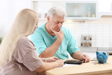 Photo of Mature couple thinking over pension payment at home