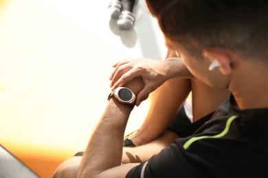 Photo of Man checking fitness tracker in gym, closeup