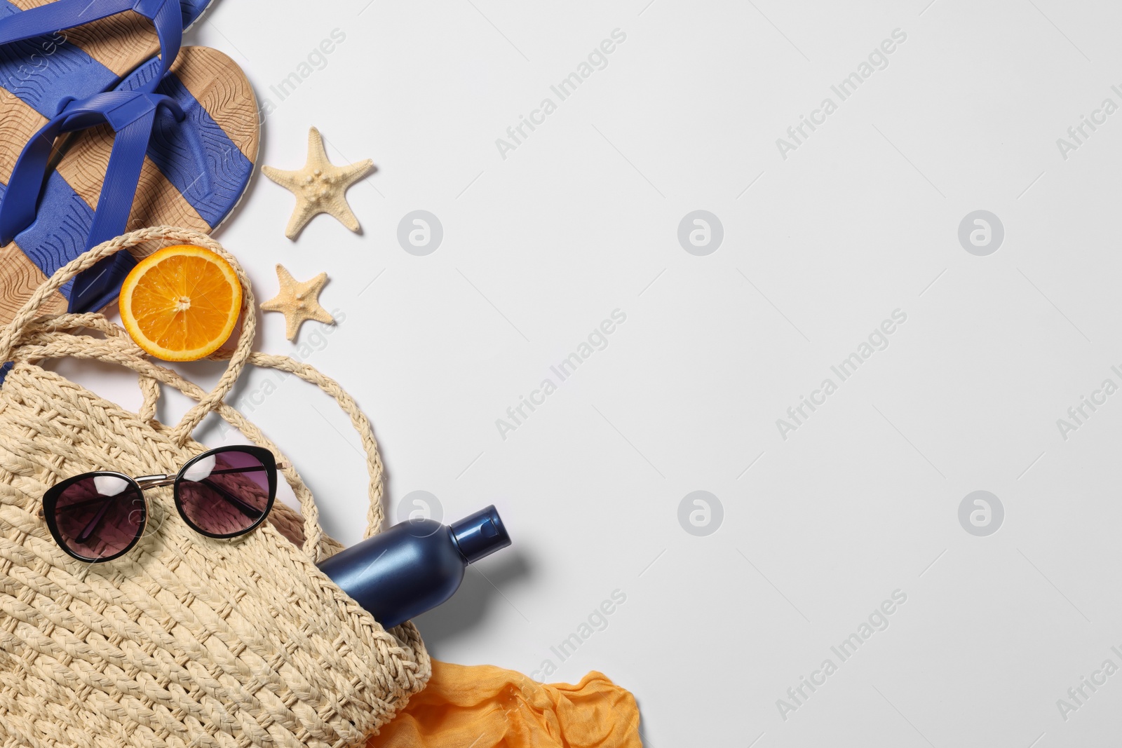Photo of Flat lay composition with wicker bag and other beach accessories on white background. Space for text