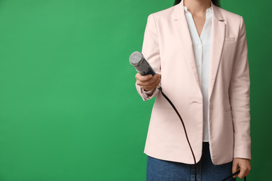 Photo of Journalist with microphone on green background, closeup. Space for text