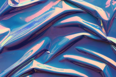 Photo of Crumpled turquoise foil as background, closeup view