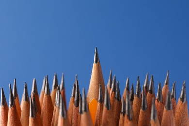 Sharp graphite pencils on blue background, closeup