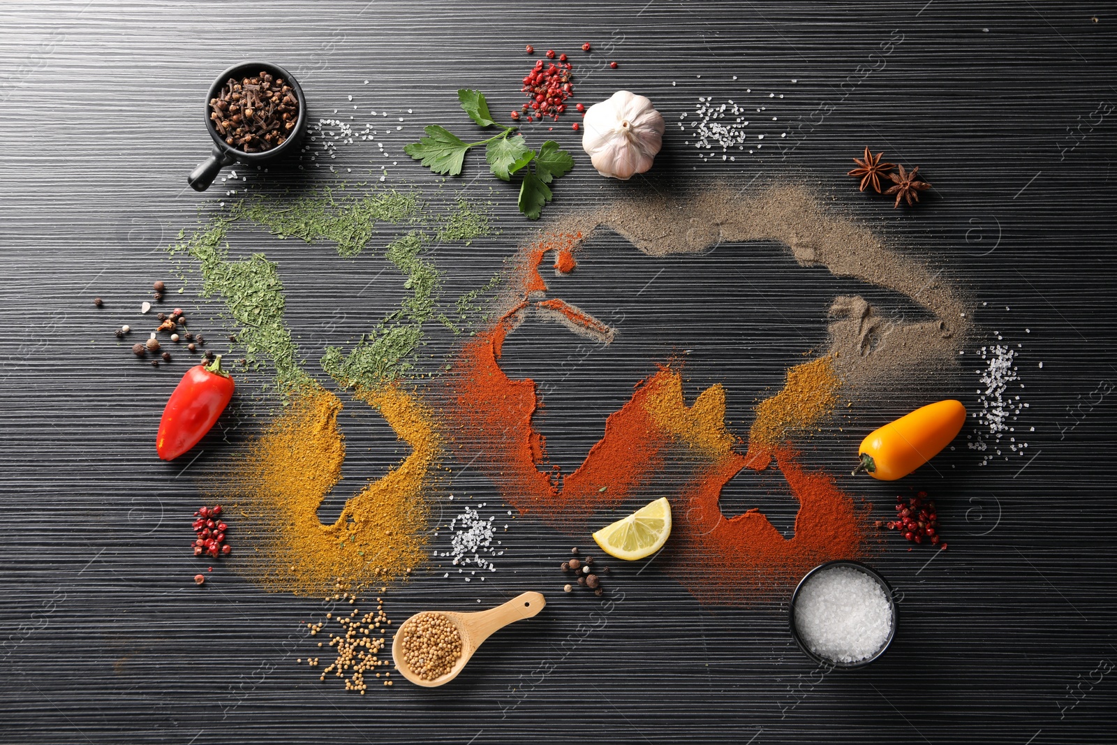 Photo of World map of different spices and products on black wooden table, flat lay