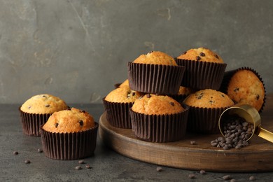 Delicious freshly baked muffins with chocolate chips on gray table