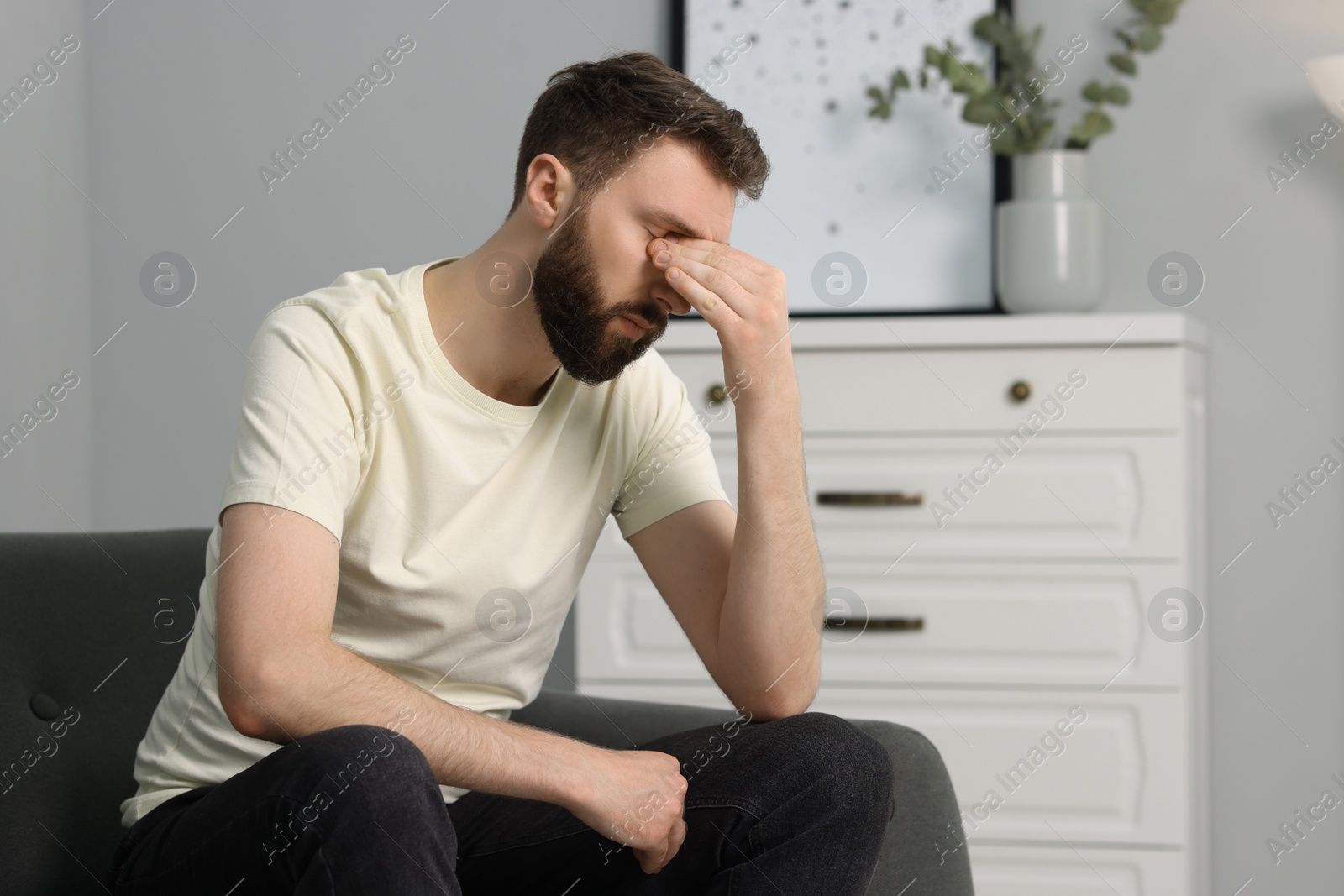 Photo of Overwhelmed man suffering from headache at home