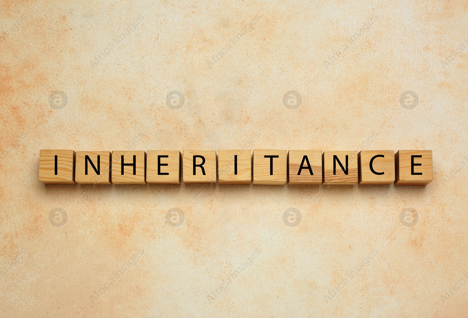 Photo of Word Inheritance made with wooden cubes on beige background, flat lay