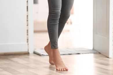 Photo of Young woman walking barefoot at home, closeup. Heating concept