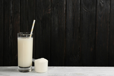 Photo of Protein shake and powder on white wooden table, space for text