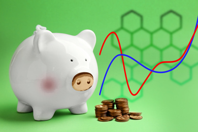 Image of White piggy bank with coins and graph on green background
