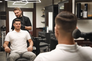 Photo of Professional hairdresser making stylish haircut in salon