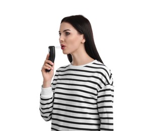 Photo of Woman blowing into breathalyzer on white background