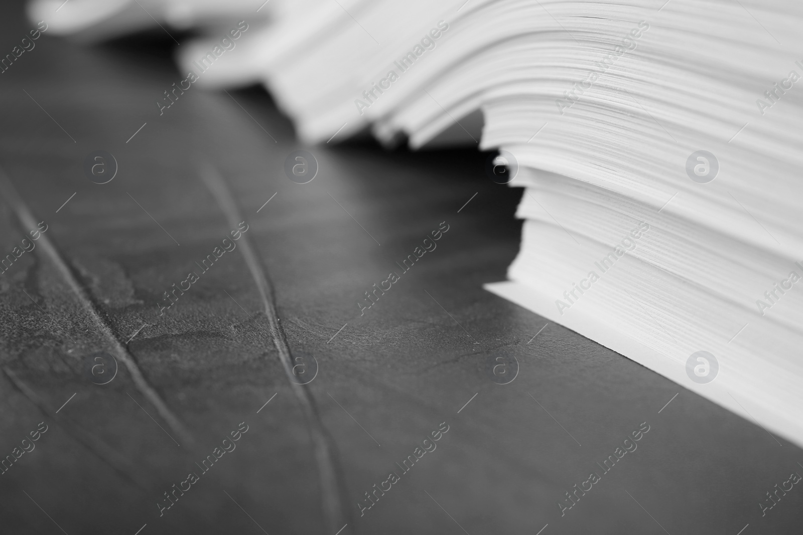 Photo of Stack of blank paper on grey stone table, closeup. Space for text