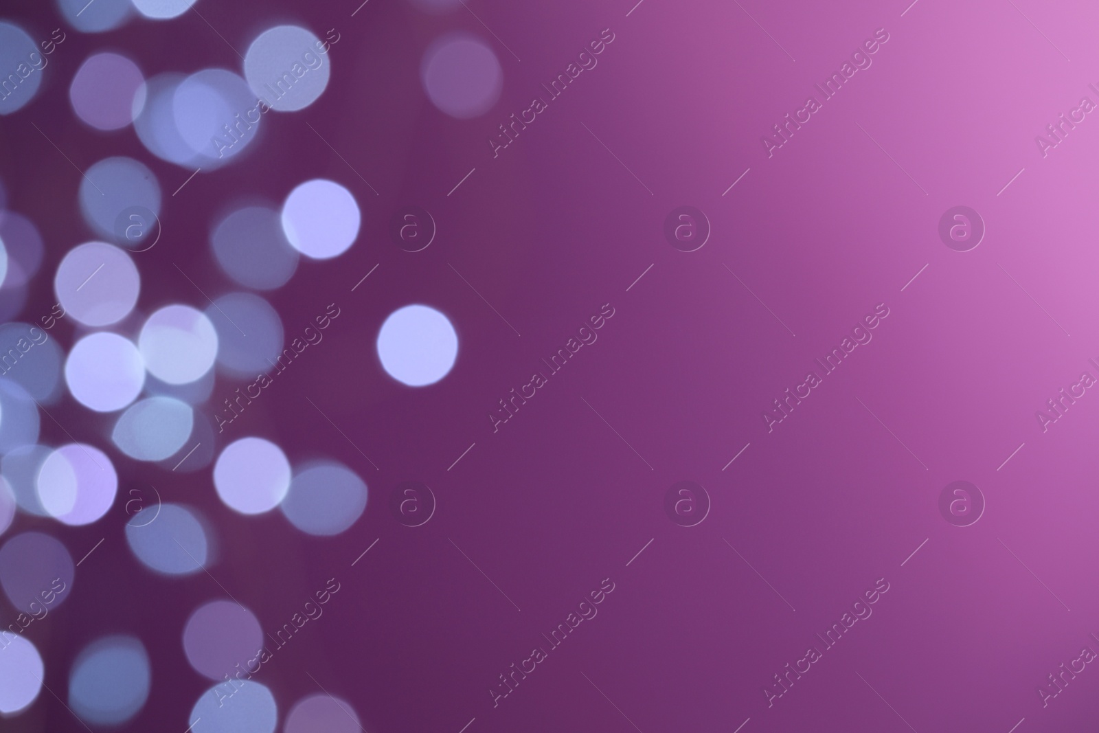 Photo of Blurred view of festive lights on purple background, space for text. Bokeh effect