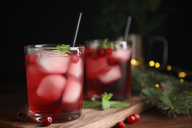 Photo of Tasty refreshing cranberry cocktail with mint on wooden table. Space for text