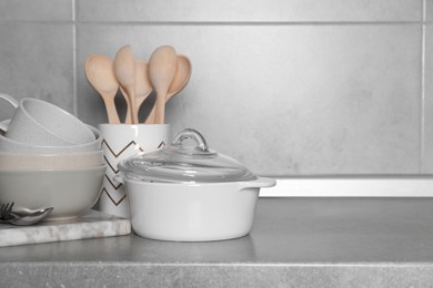 Cooking utensils and other kitchenware on grey countertop. Space for text