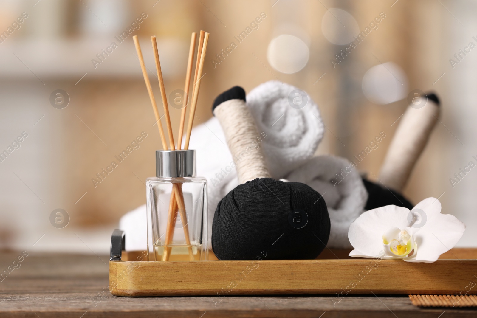 Photo of Composition with different spa products and beautiful orchid flower on wooden table against blurred background