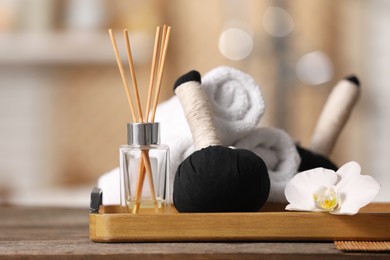 Photo of Composition with different spa products and beautiful orchid flower on wooden table against blurred background