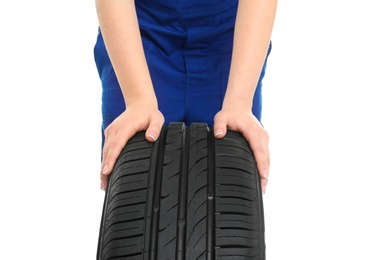 Female mechanic with car tire on white background, closeup