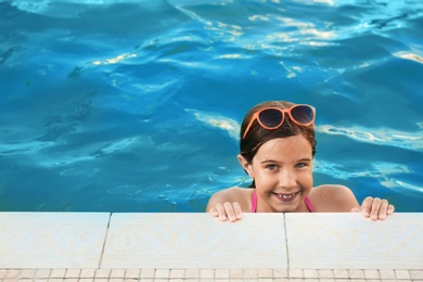 Happy cute girl with sunglasses in swimming pool