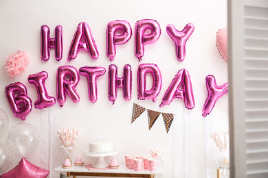 Phrase HAPPY BIRTHDAY made of pink balloon letters in decorated room