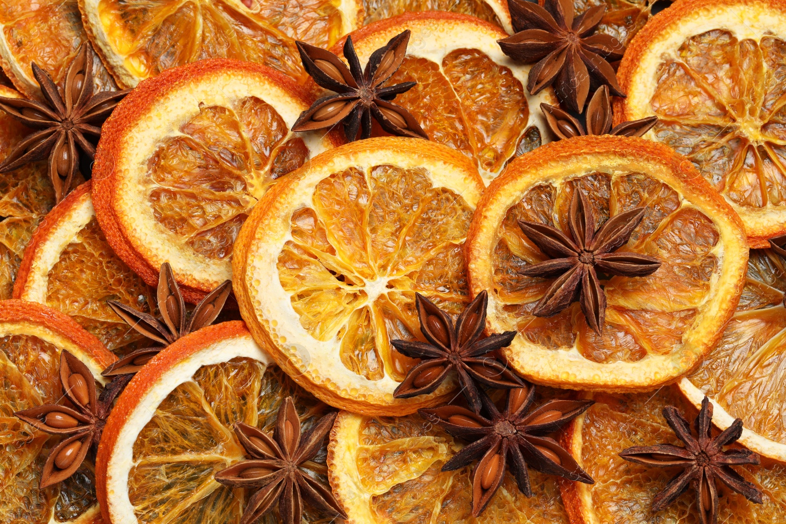 Photo of Dry orange slices and anise stars as background, top view