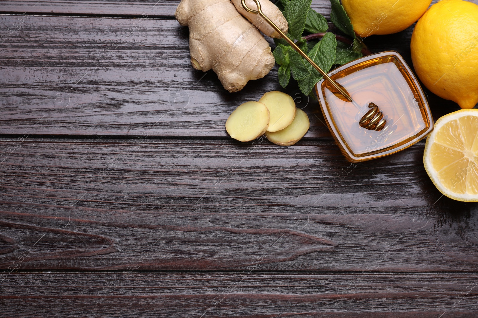 Photo of Natural cough remedies. Bowl with honey, ginger, lemon and mint on wooden table, flat lay. Space for text