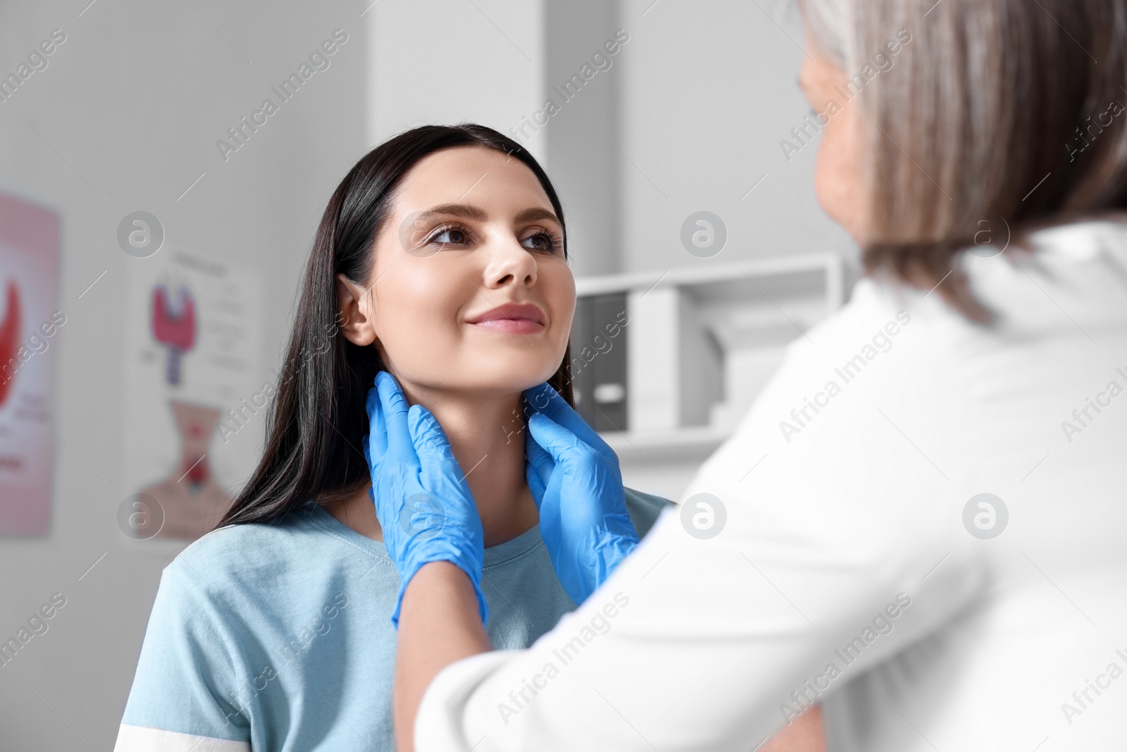 Photo of Endocrinologist examining thyroid gland of patient at hospital