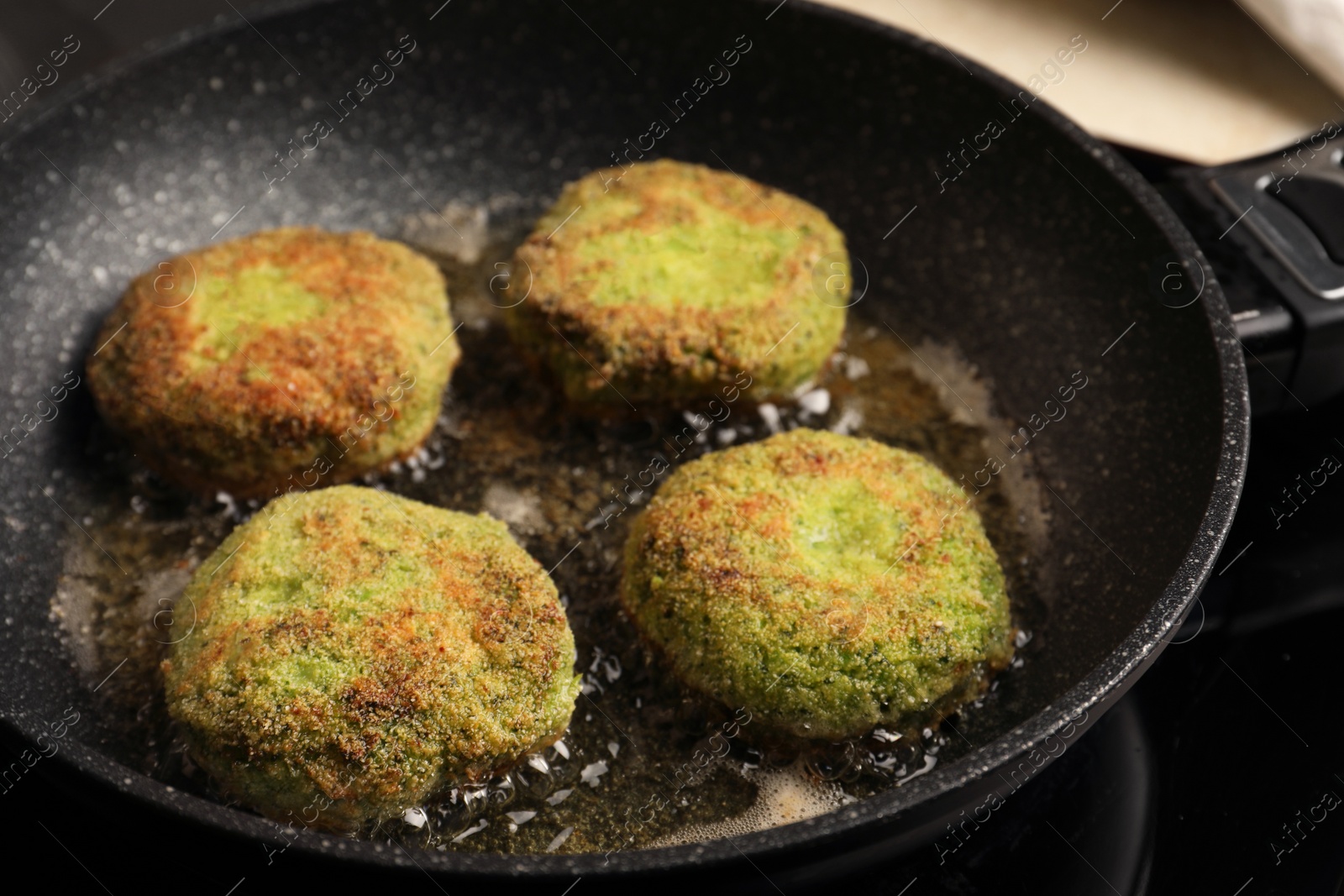 Photo of Cooking vegan cutlets in frying pan on stove, closeup