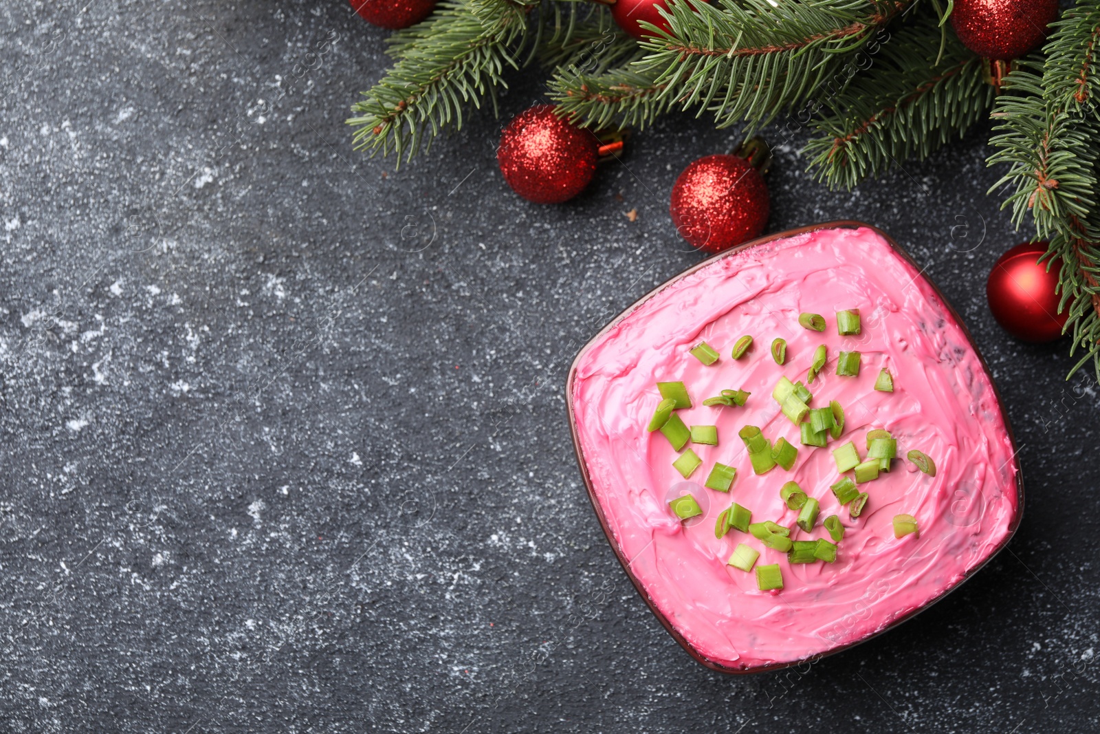 Photo of Herring under fur coat salad and Christmas decor on grey table, flat lay with space for text. Traditional Russian dish